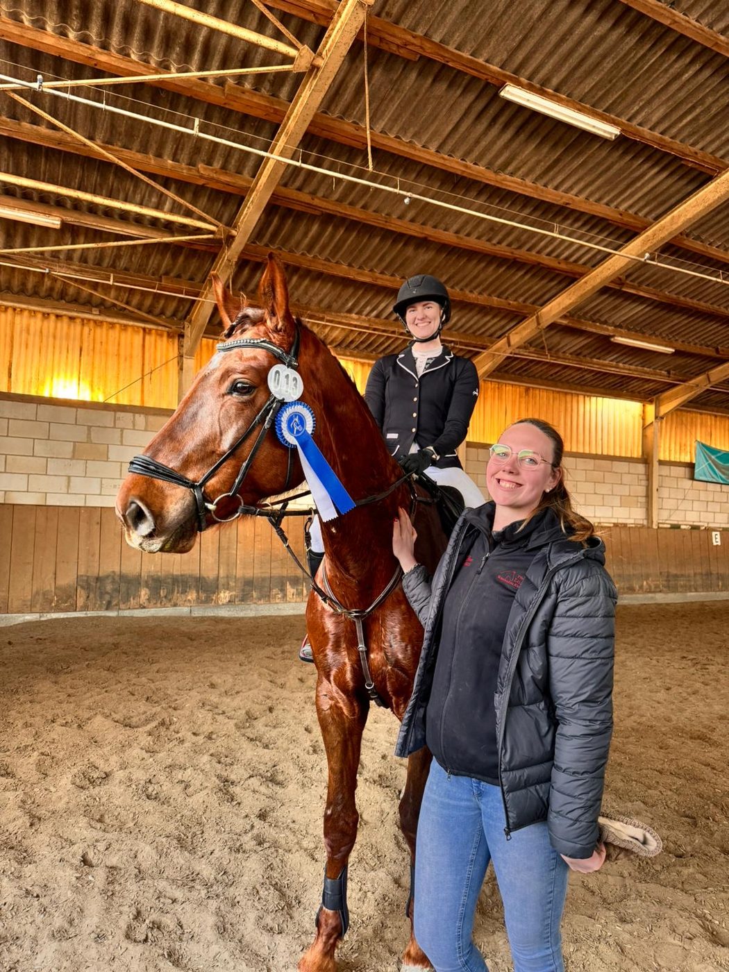 Anke Braun mit Pferd und Turnierschleife